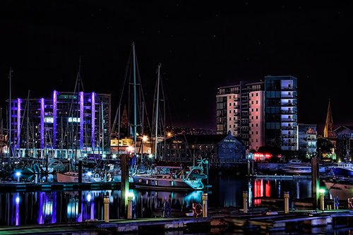 Photo of Plymouth Barbican by night with moored boats, yachts and buildings